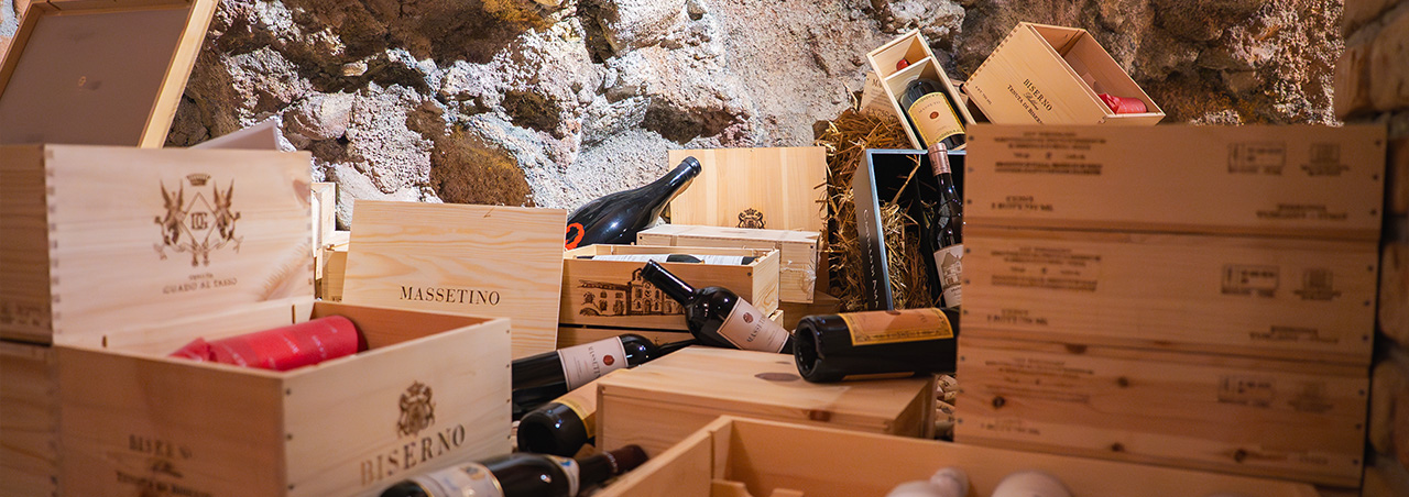 Ein Weinlager aus Stein und Ziegeln mit Holzkisten von den Spitzenweingütern Masseto und Opus One
