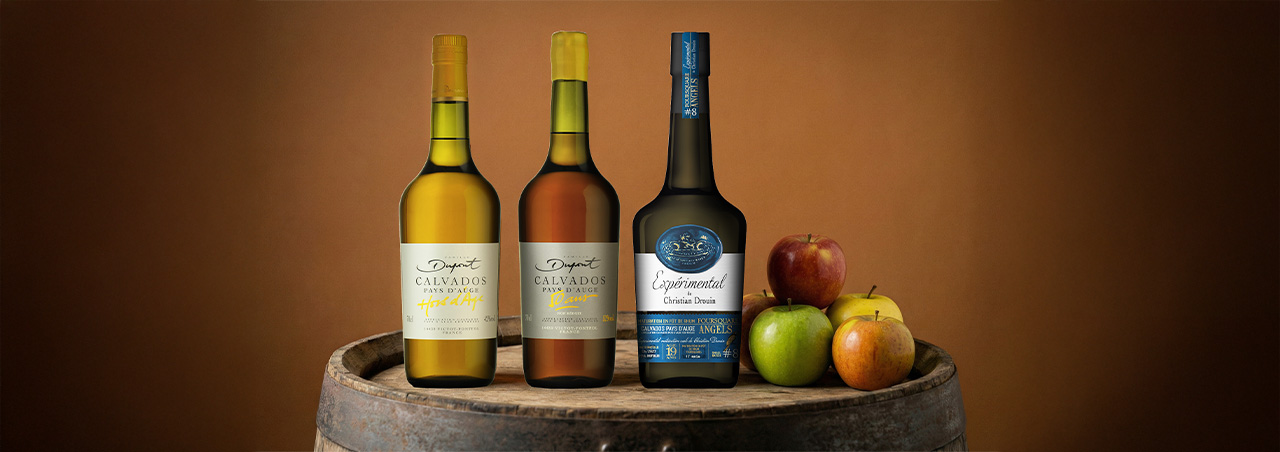 Photo mettant en avant trois bouteilles de calvados.