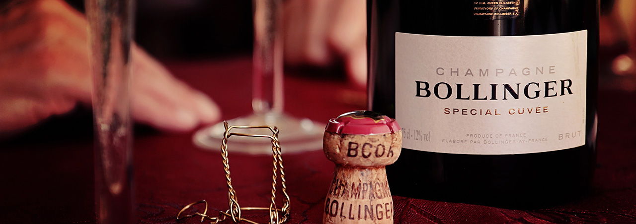 Nahaufnahme einer Bollinger Special Cuvée Flasche, das Etikett ist klar sichtbar. Im Vordergrund der entfernte Korken
