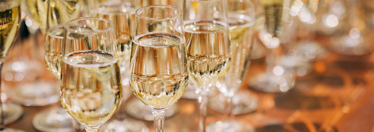 Auf einem Holztisch angerichtete gefüllte Champagner-Gläser