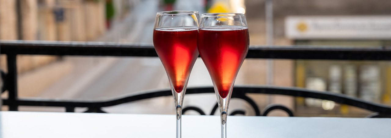  Kir Royal, französischer Aperitif-Cocktail aus Crème de Cassis und Champagner, in Tulpengläser serviert