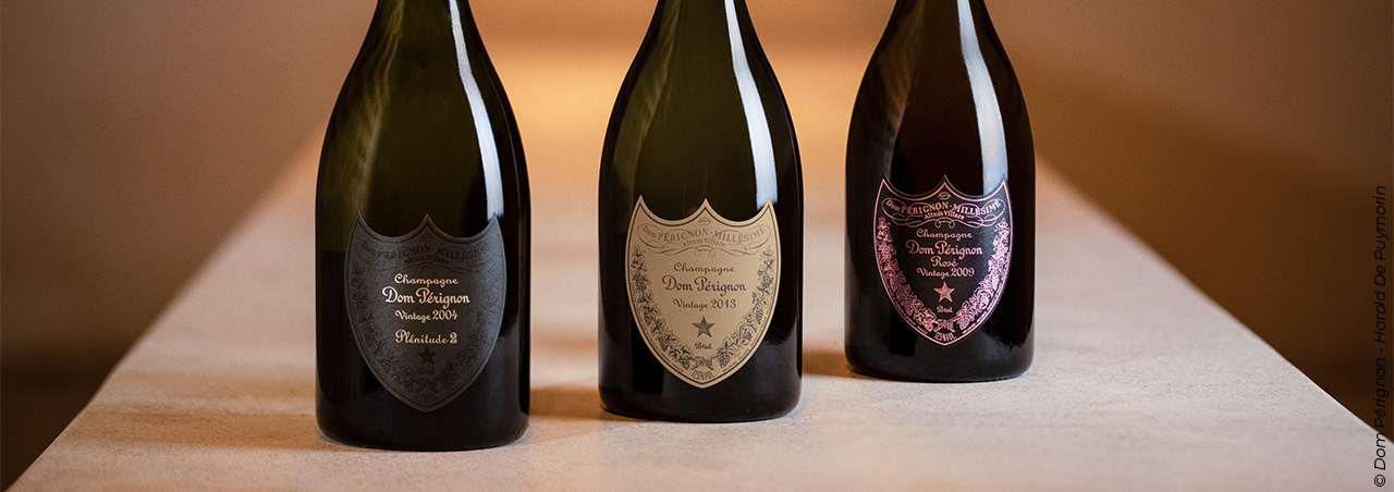 © Dom Pérignon, drei Dom-Pérignon-Flaschen aus unterschiedlichen Jahrgängen hintereinander aufgestellt