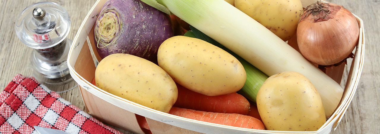 Une photographie d'un panier de légumes prêts à être utilisés pour cuisiner un pot-au-feu.