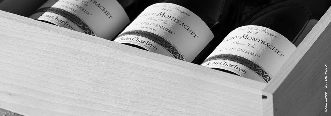 Eine Schwarz-Weiß-Fotografie einer nummerierten Holzkiste, die Puligny-Montrachet des Weinguts Jean Chartron enthält.