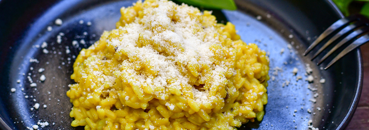 Un risotto à la milanaise, safrané, garni d'une feuille d'herbe aromatique fraîche et de fins copeaux de parmesan. 