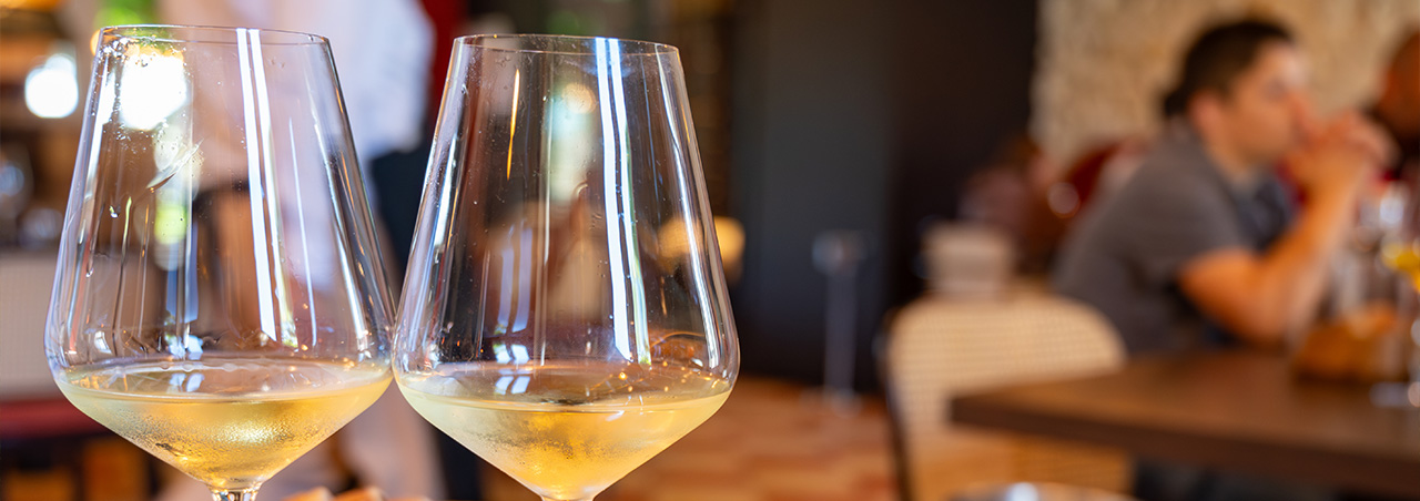 Sauternes-Tasting in Bordeaux, Frankreich. Weingläser auf Holztisch, im Hintergrund geschnittenes Brot