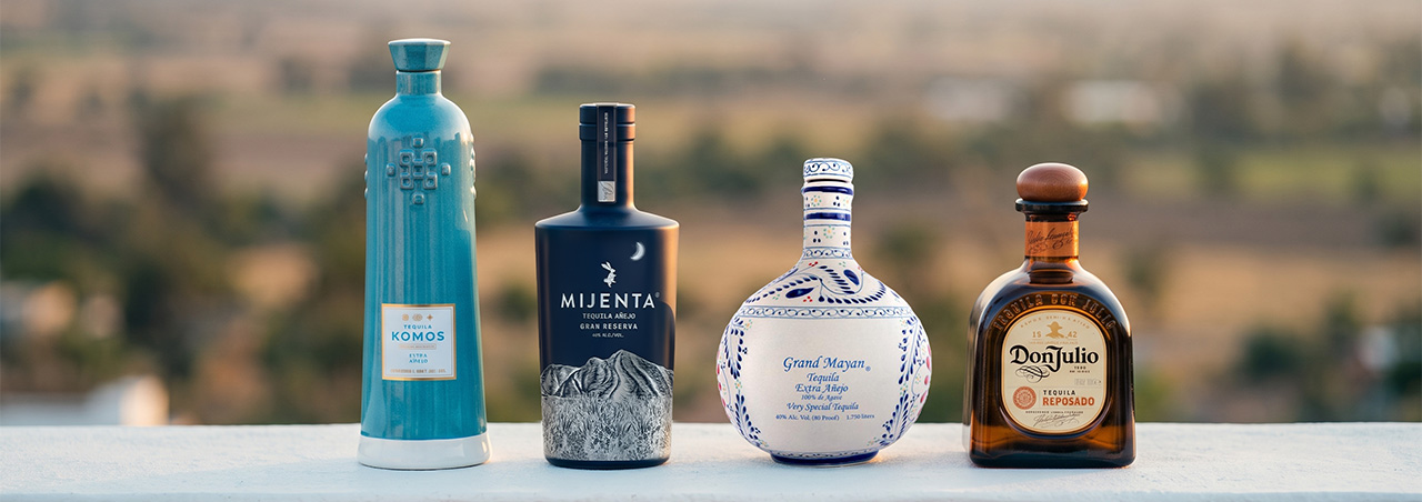 Une photographie mettant en scène quatre flacons de tequila de prestige, issus des maisons Don Julio, Grand Mayan, Komos et Mijenta.
