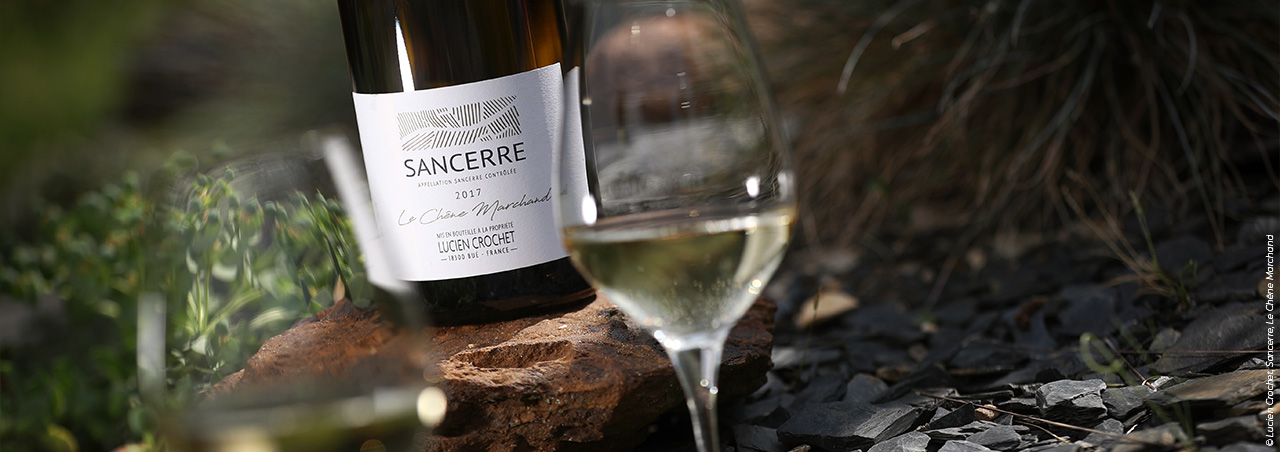 © Lucien Crochet, Sancerre-Weinflasche Le Chêne Marchand, im Vordergrund zwei gefüllte Weingläse auf Schieferboden