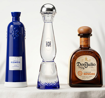 Une photographie mettant en scène trois flacons de tequila de prestige : Komos, Don Julio et Clase Azul.