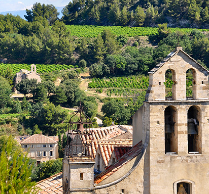 Idyllische Aufnahme von Weinbergen im Weinbaugebiet Gigondas in Südfrankreich, im Vordergrund eine historische Kirche
