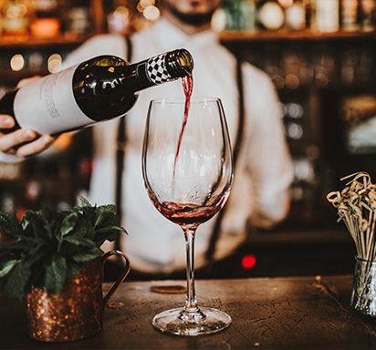 Bartender serviert Rotwein am Tresen