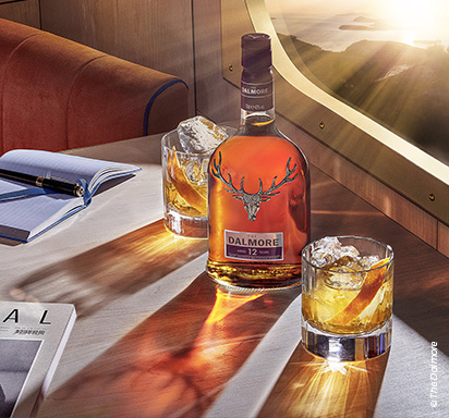 Une bouteille de whisky The Dalmore accompagnée de deux verres servis avec des glaçons.
