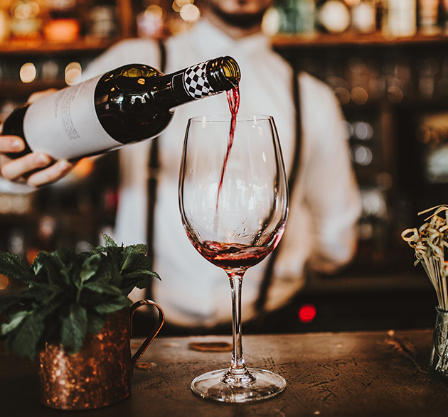 Bartender serviert Rotwein am Tresen