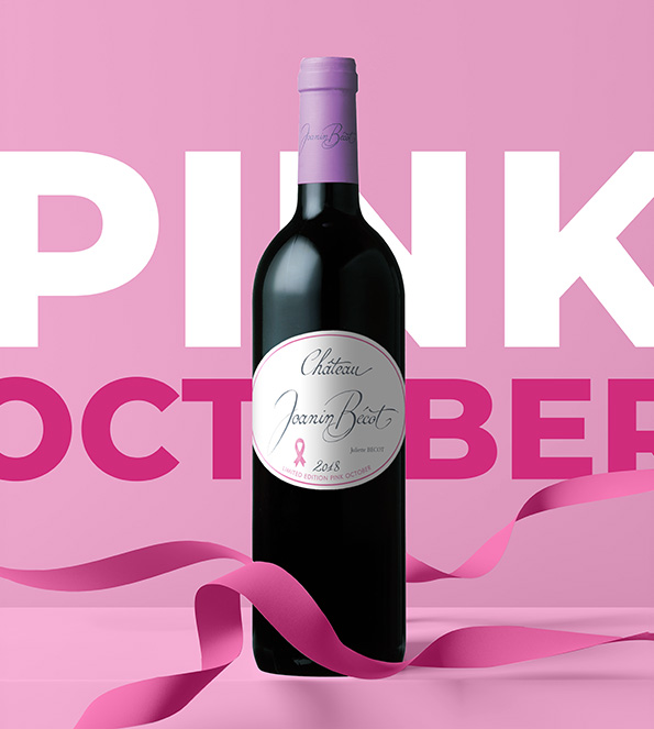A bottle of Château Joanin Bécot lying down with a pink ribbon